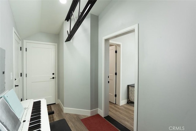 hallway with electric panel and hardwood / wood-style flooring