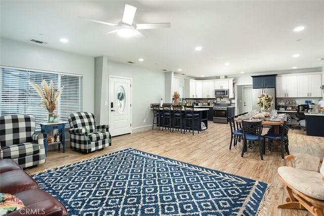 living room with wood-type flooring and ceiling fan