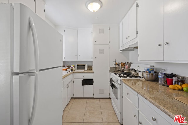 kitchen with light tile patterned floors, white appliances, and white cabinetry