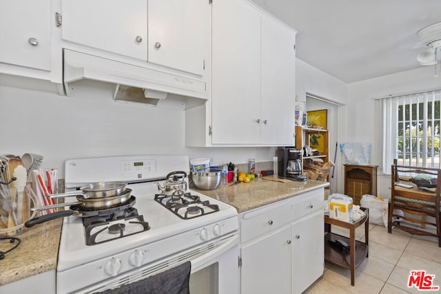 kitchen featuring white cabinetry, white gas stove, and light tile patterned floors