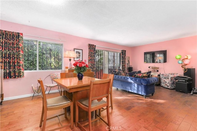 dining area with hardwood / wood-style floors and a textured ceiling