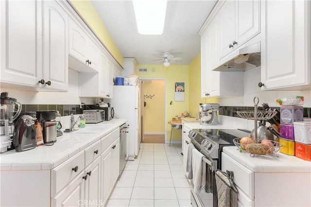 kitchen with tile counters, white cabinetry, and appliances with stainless steel finishes