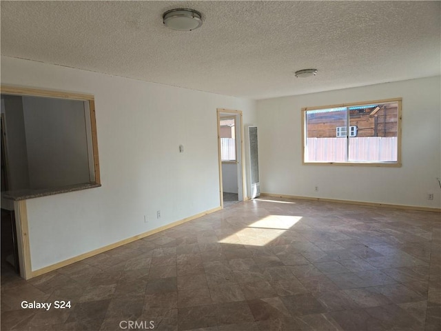 unfurnished room with a textured ceiling