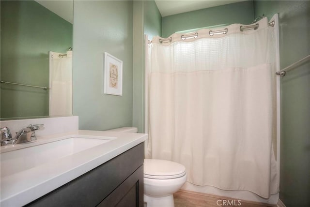 bathroom with toilet, vanity, and hardwood / wood-style flooring