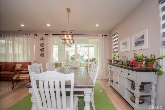 dining space with a chandelier and light hardwood / wood-style flooring