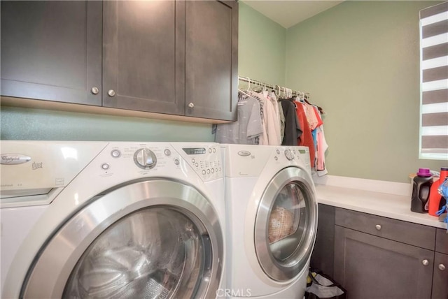 clothes washing area with cabinets and separate washer and dryer