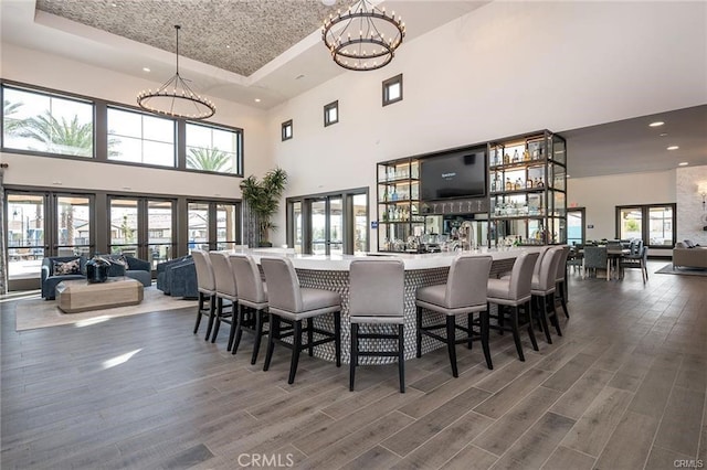 dining room featuring a chandelier, a towering ceiling, and dark hardwood / wood-style floors