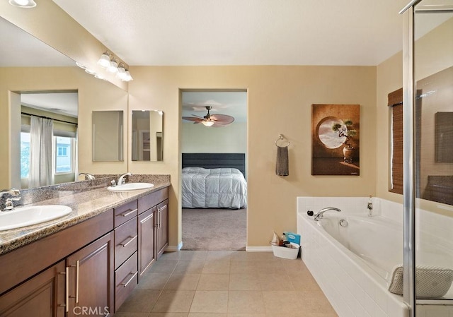 bathroom with tile patterned flooring, vanity, tiled bath, and ceiling fan