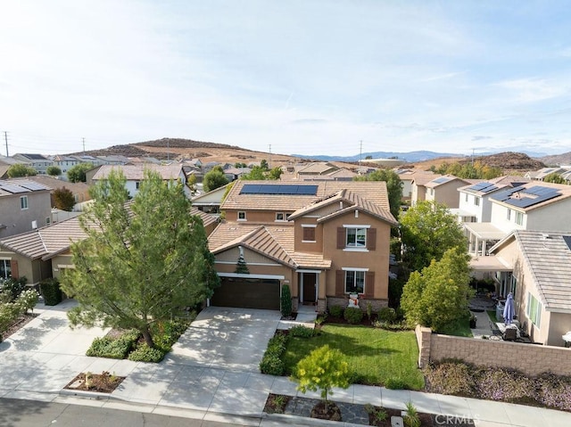 view of front of house with solar panels, a garage, and a mountain view