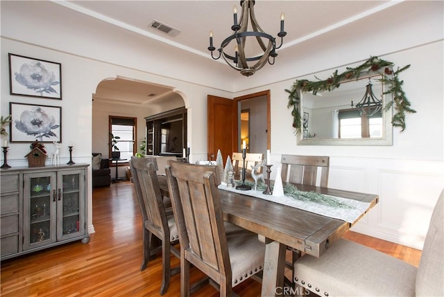 dining space with wood-type flooring and a chandelier