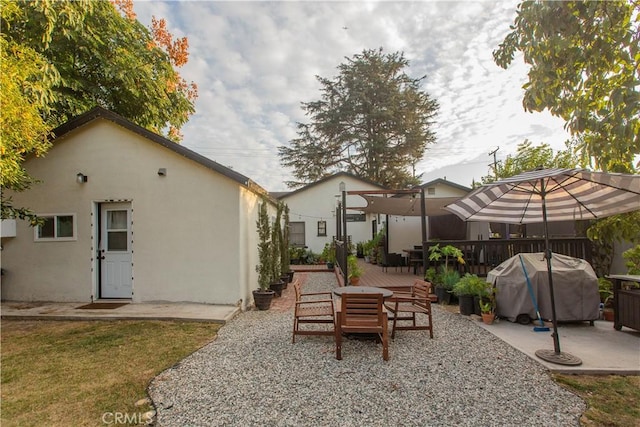 back of property with a yard, a patio, and a deck