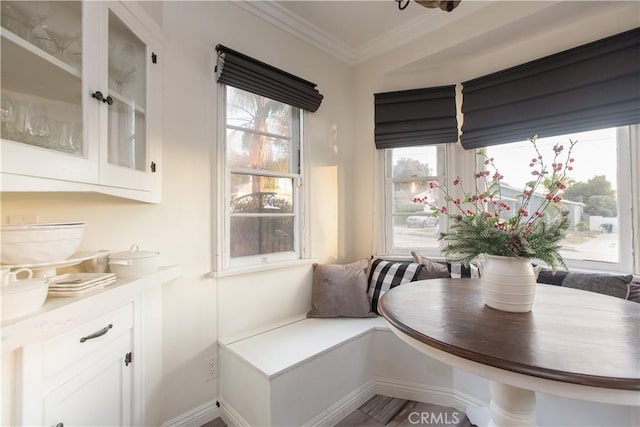 dining space featuring breakfast area, a healthy amount of sunlight, and crown molding