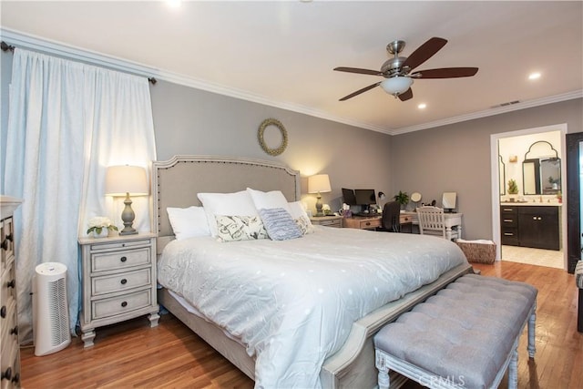 bedroom featuring hardwood / wood-style flooring, ceiling fan, crown molding, and ensuite bath