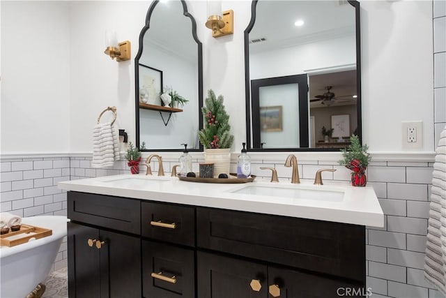 bathroom featuring vanity, a bathtub, tile walls, and crown molding