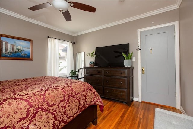 bedroom with light wood-type flooring, ceiling fan, and ornamental molding