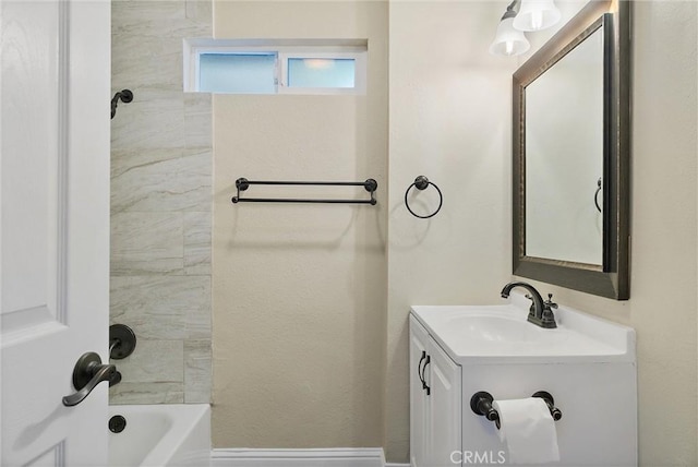 bathroom with tiled shower / bath combo and vanity