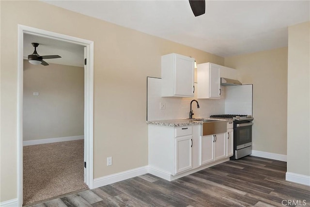 kitchen featuring dark wood-type flooring, white cabinetry, sink, gas range, and range hood