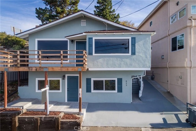 view of front of home featuring a balcony and a patio area