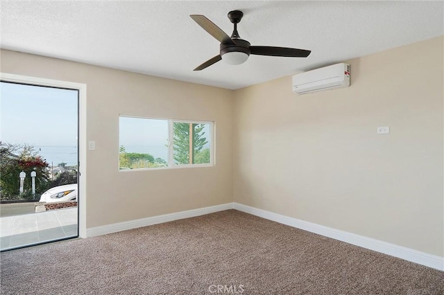 carpeted spare room featuring a wall unit AC and ceiling fan