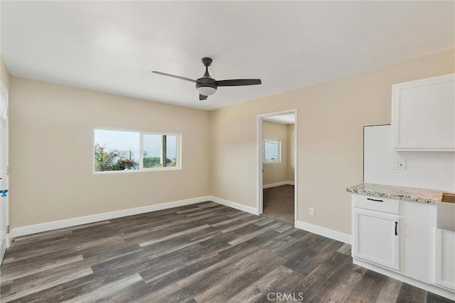 unfurnished room featuring ceiling fan and dark wood-type flooring