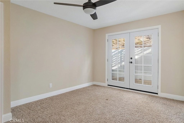 carpeted spare room featuring ceiling fan and french doors