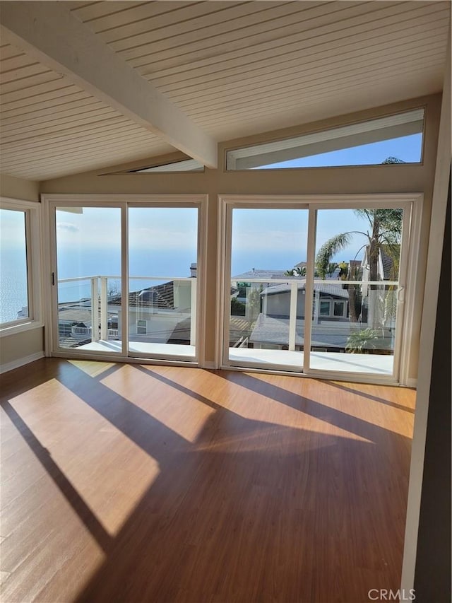 unfurnished sunroom with lofted ceiling with beams