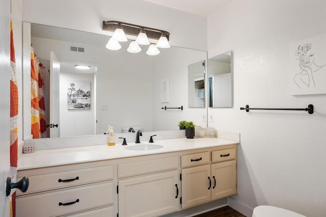 bathroom with hardwood / wood-style floors, vanity, and toilet