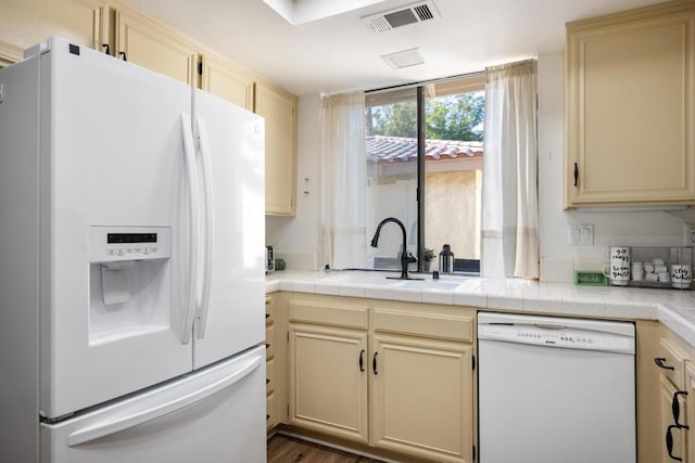 kitchen featuring white appliances, sink, cream cabinets, tile countertops, and dark hardwood / wood-style floors