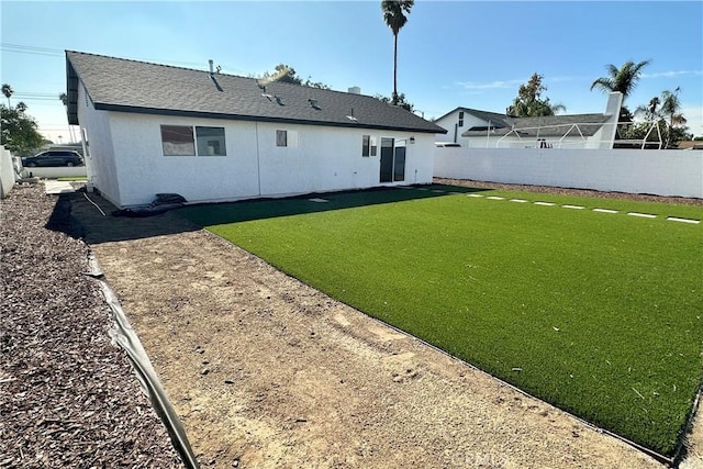 rear view of house featuring a yard