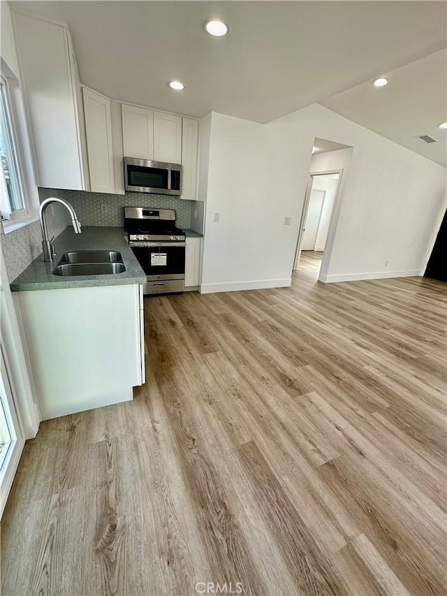 kitchen featuring white cabinets, sink, light wood-type flooring, and stainless steel appliances