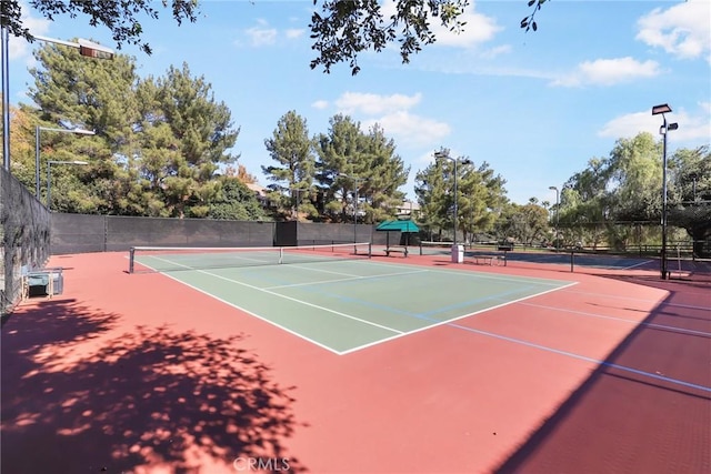 view of tennis court with basketball hoop