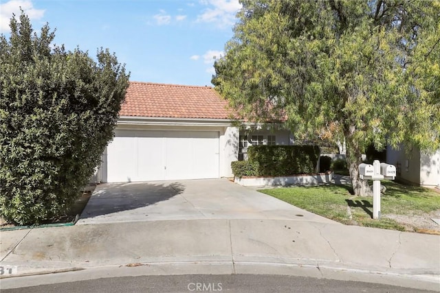 obstructed view of property with a garage and a front lawn