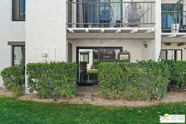 view of exterior entry with a balcony