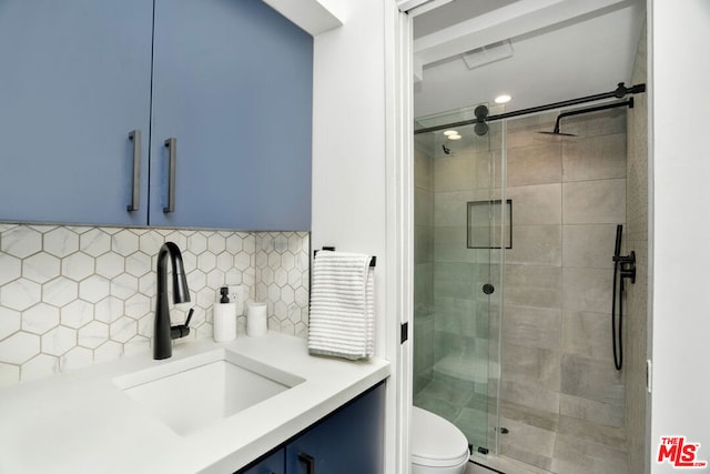 bathroom with toilet, tasteful backsplash, walk in shower, and vanity