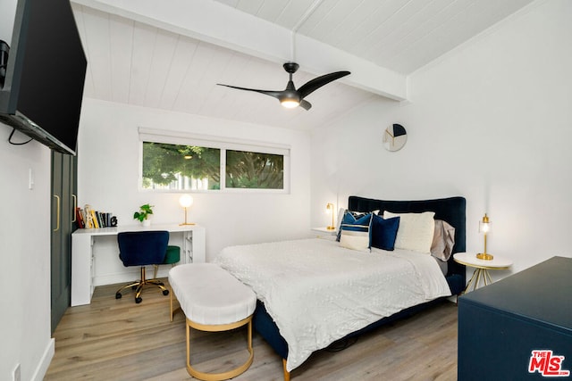 bedroom with ceiling fan, hardwood / wood-style floors, and beam ceiling