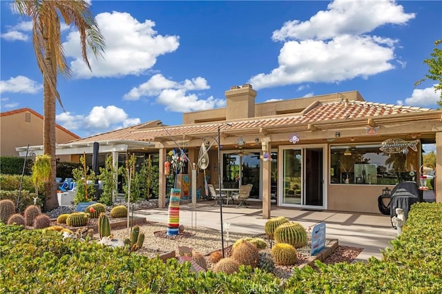 rear view of property featuring ceiling fan and a patio