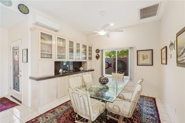 dining room featuring an AC wall unit, ceiling fan, and light tile patterned flooring