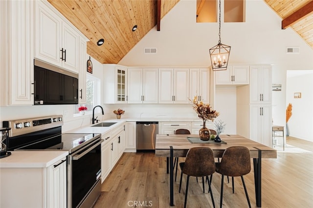 kitchen featuring white cabinets, pendant lighting, and appliances with stainless steel finishes