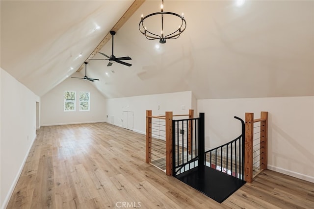 additional living space with vaulted ceiling with beams, ceiling fan with notable chandelier, and light wood-type flooring