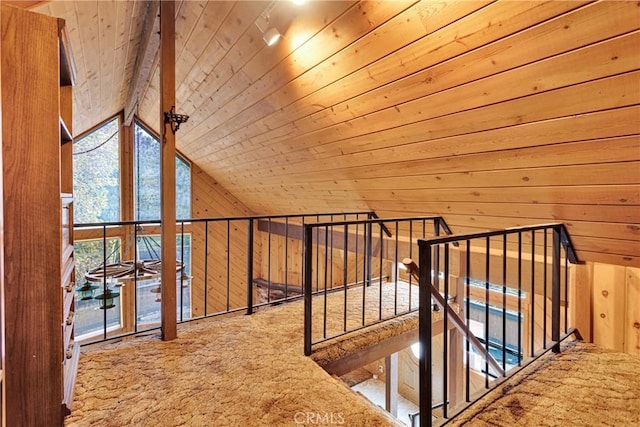 interior space with carpet, vaulted ceiling, wood walls, and wood ceiling