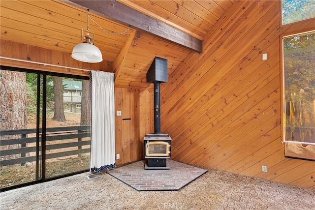 details with a wood stove, beamed ceiling, wood walls, carpet, and wood ceiling