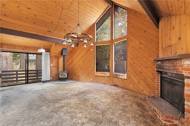 unfurnished living room with wood ceiling, heating unit, beam ceiling, carpet floors, and wood walls