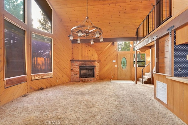 unfurnished living room featuring wood walls, a fireplace, and high vaulted ceiling