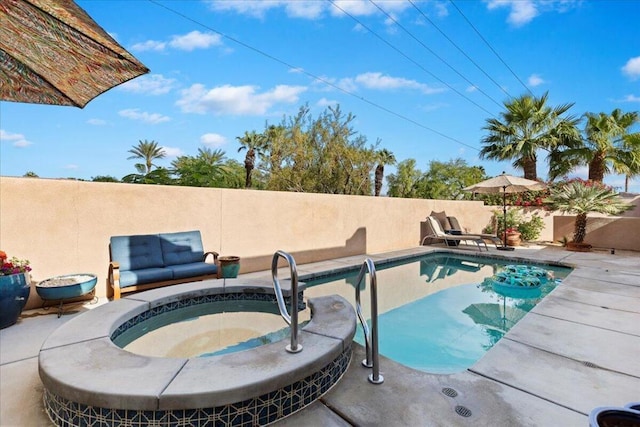 view of swimming pool featuring a patio area and a hot tub