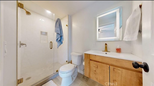 bathroom featuring tile patterned flooring, vanity, a shower with door, and toilet