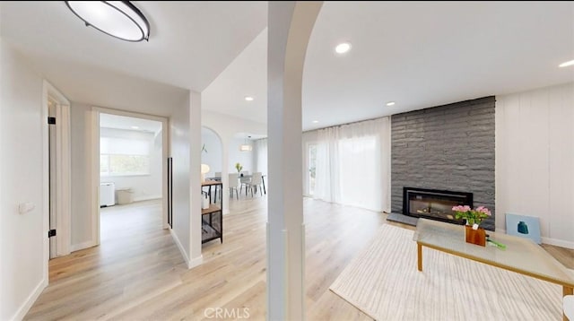 living room featuring light hardwood / wood-style floors and a stone fireplace