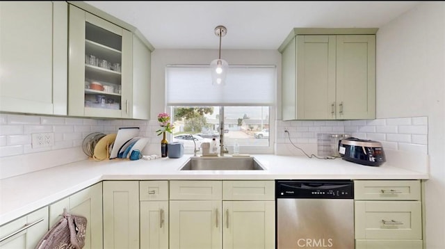 kitchen featuring stainless steel dishwasher, decorative light fixtures, sink, and tasteful backsplash