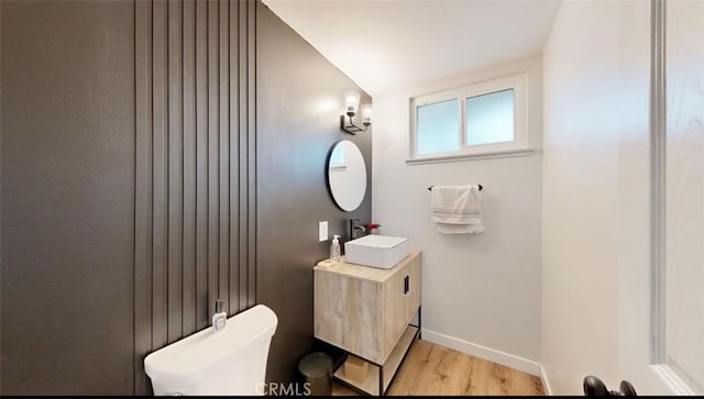 bathroom featuring hardwood / wood-style floors, vanity, toilet, and lofted ceiling