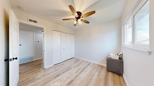 unfurnished bedroom with ceiling fan, light hardwood / wood-style floors, and a closet