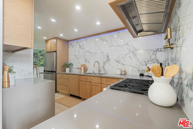 kitchen featuring sink, light brown cabinets, stainless steel refrigerator, backsplash, and wall chimney range hood